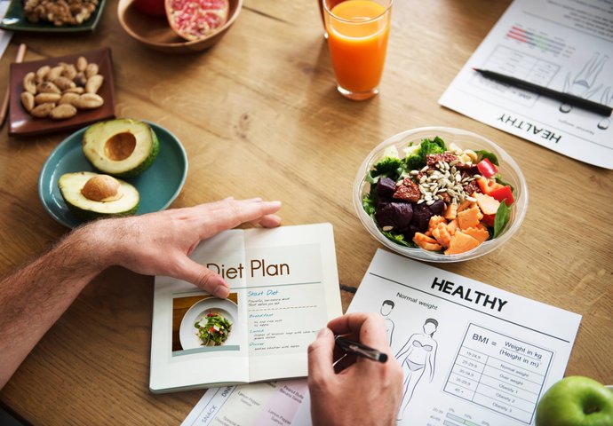 Healthy meal and fitness journal on table